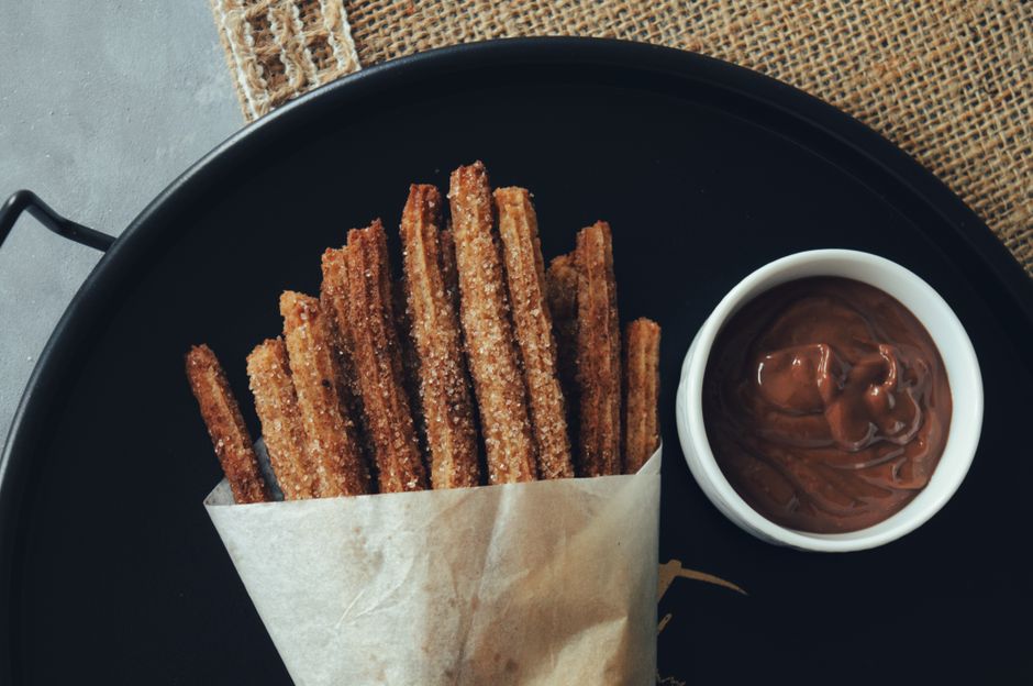 Churros dorés saupoudrés de sucre et de cannelle avec une sauce au chocolat