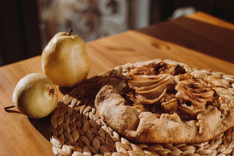 Galette des Rois à la frangipane, dorée et feuilletée, posée sur une table en bois