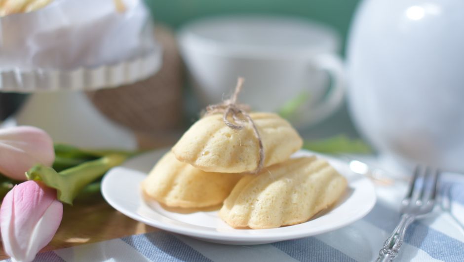 Madeleines dorées disposées sur une assiette en porcelaine